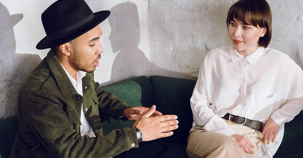 A couple chats in a corner booth.