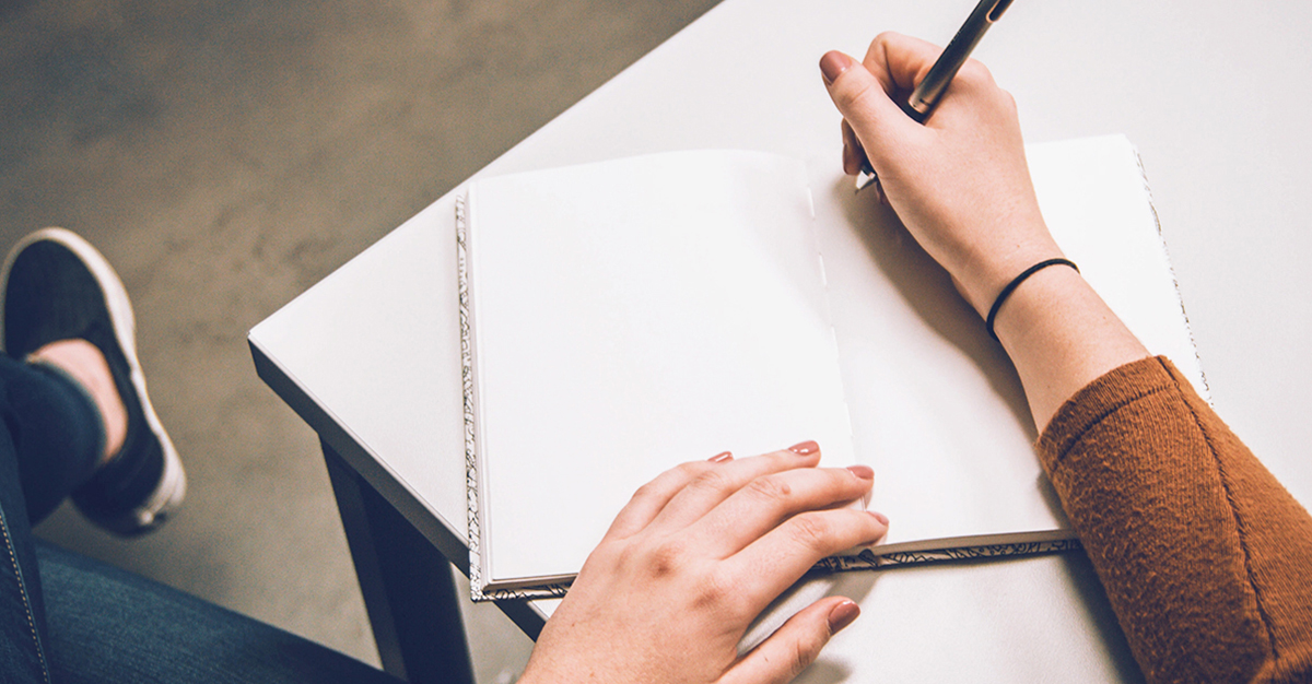 A woman writes in her journal. 