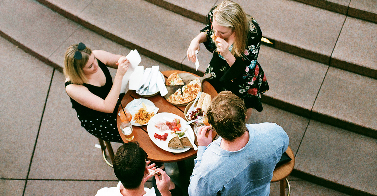 A group of friends eating together outside.