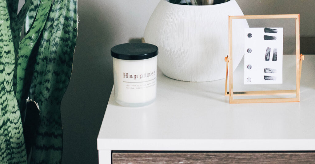 Candle and plant on nightstand